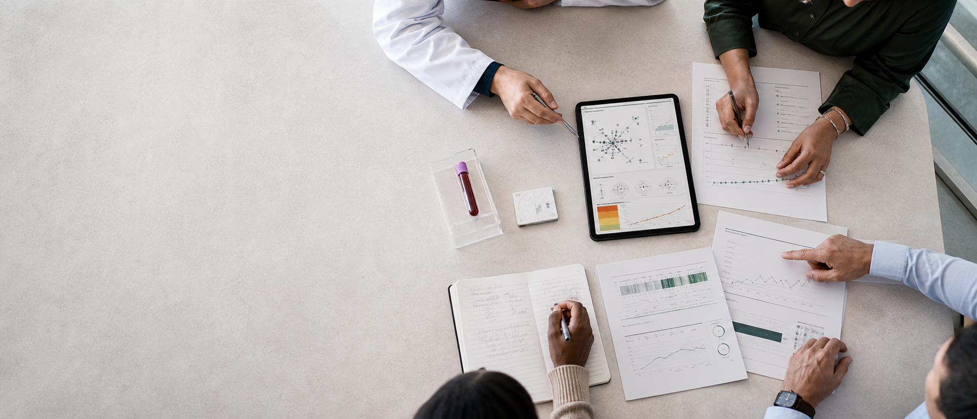 Clinical and research team reviewing longitudinal risk trajectory charts and molecular data around a lab table